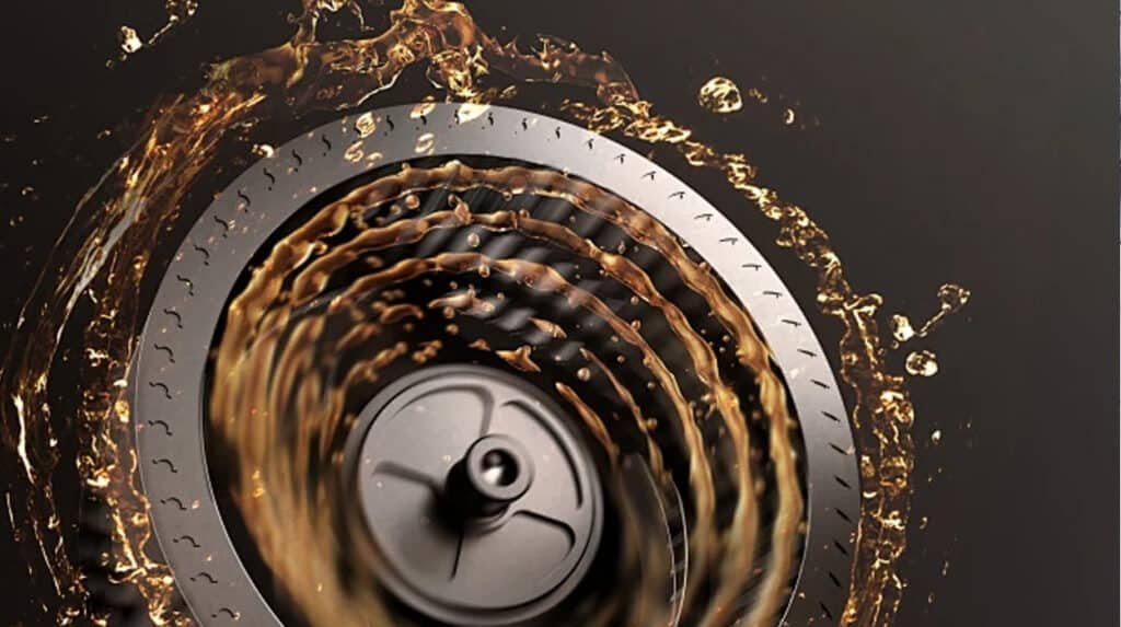 Spinning engine bearing surrounded by splashing golden oil demonstrating hydrodynamic lubrication regime where speed viscosity and load create full separating film preventing metal contact and wear
