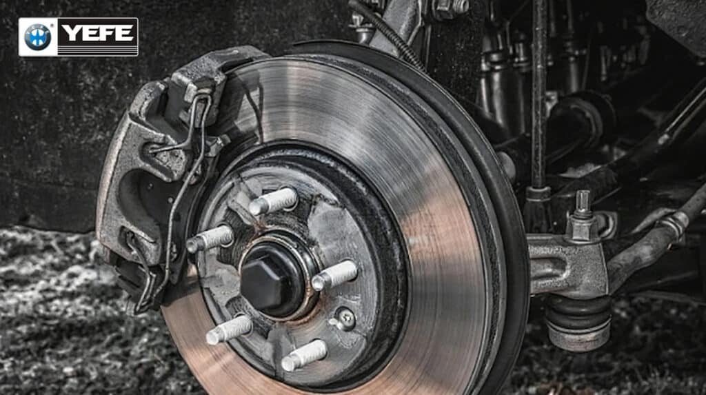 Close-up of a vehicle disc brake rotor, caliper and hub with wheel removed, illustrating the braking hardware that relies on proper YEFE brake fluid level and condition to maintain hydraulic pressure, pedal feel and safe stopping distances.
