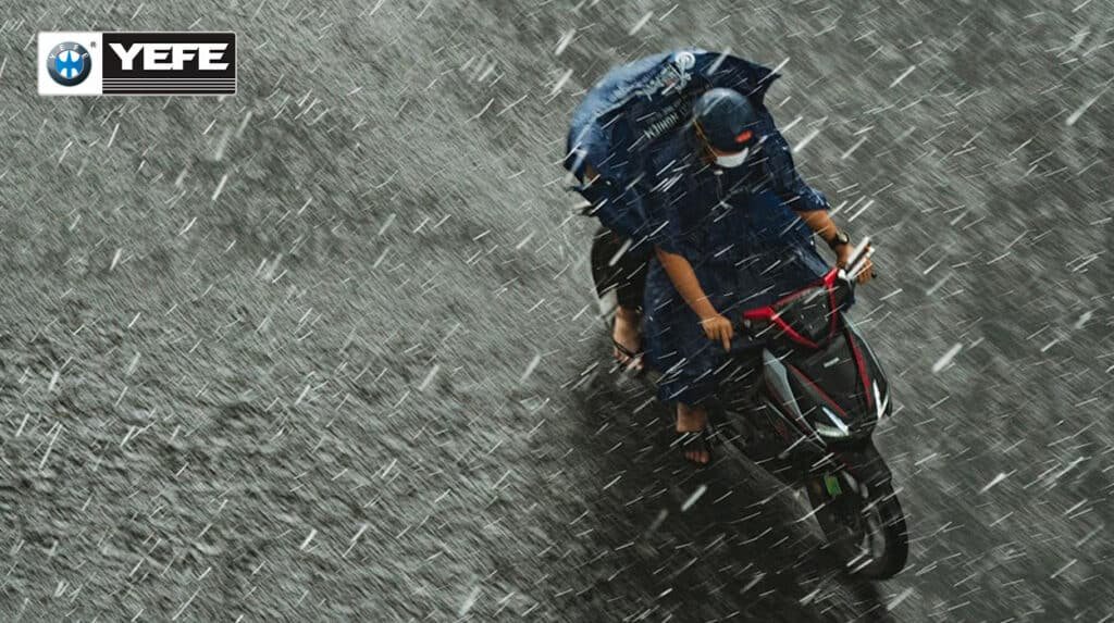 YEFE motorcycle rider in rainy weather conditions demonstrating the importance of proper motorcycle oil viscosity selection between 10W-40 and 20W-50 grades for engine protection in challenging climates, showing how environmental factors and riding conditions affect oil performance and viscosity stability