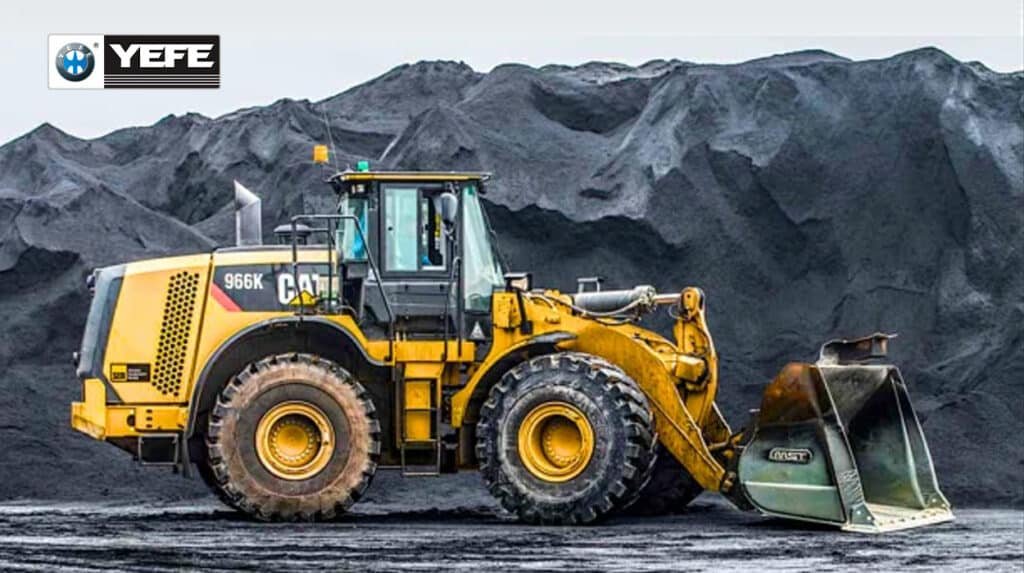 Large yellow mining dump truck being loaded with rock in a quarry, illustrating harsh, dusty conditions where hydraulic oil faces contamination, oxidation, viscosity breakdown, and foaming, requiring high-quality YEFE hydraulic oil and proper maintenance to avoid failures.