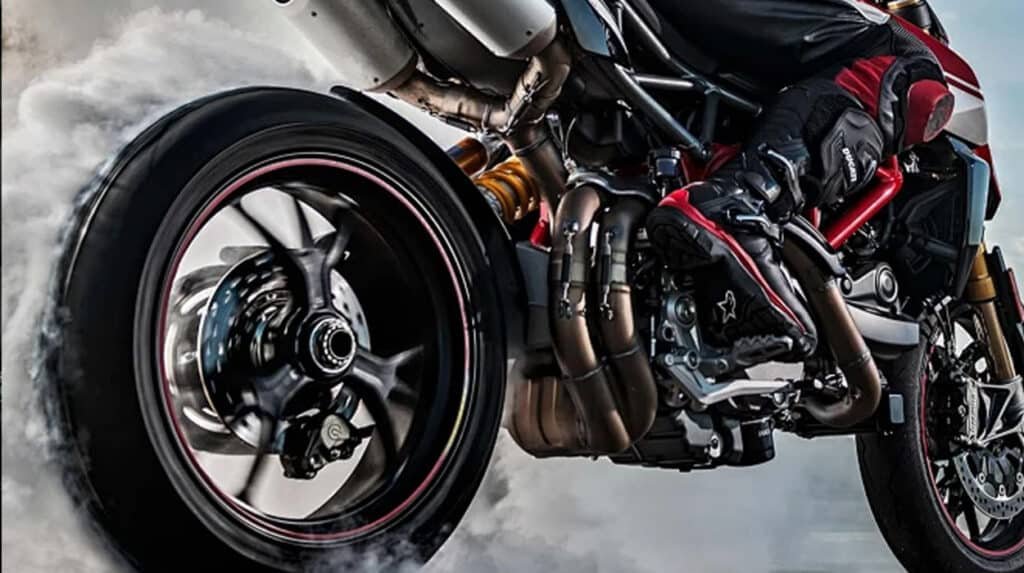 Sport motorcycle performing a burnout with rear wheel spinning and smoke, illustrating high-stress conditions where SAE 20W-50 motorcycle oil provides superior thermal stability and viscosity retention compared to 10W-40 in hot climates and heavy loads.