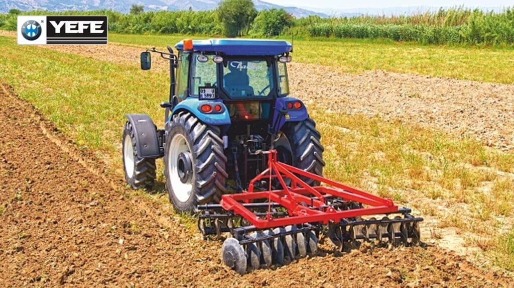 Agricultural tractor with red tillage implement working in the field, powered by YEFE hydraulic oil that protects multi-function farm equipment systems in seasonal agricultural conditions