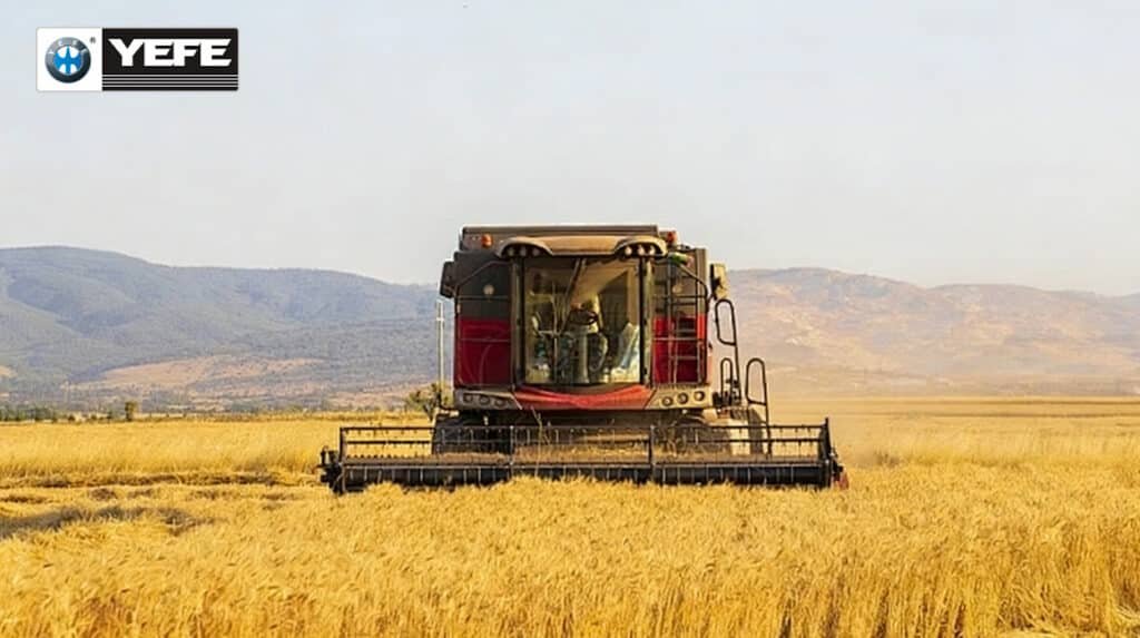 YEFE transmission oil for agricultural machinery showing combine harvester operating in wheat field with dust and heavy loads, demonstrating the need for specialized agricultural transmission fluid with shear stability, thermal protection, anti-wear additives, and contamination resistance to protect farm equipment transmissions during continuous harvesting operations, variable loads, and harsh environmental conditions