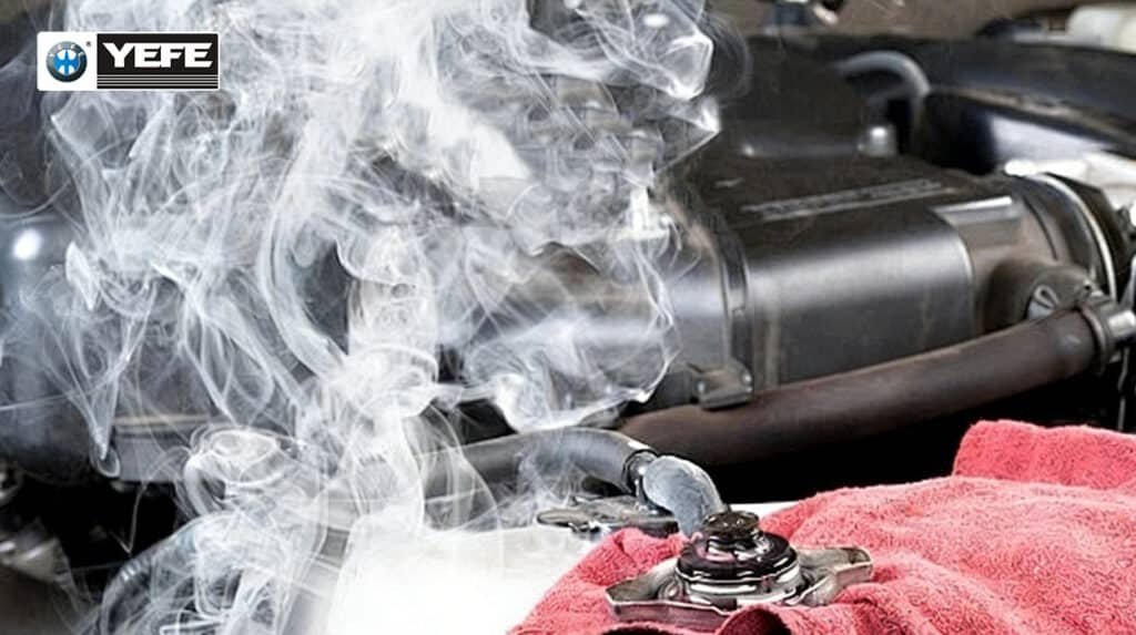 White steam rising from a car's open radiator cap, indicating an overheating engine issue. A red towel is placed nearby for safety during inspection.