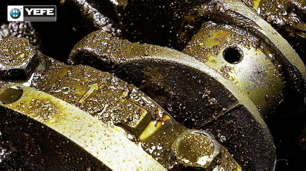A close-up view of a heavily sludged engine interior, showing thick, black deposits coating the internal components. This image visually demonstrates the severe result of using the wrong engine oil or neglecting oil changes, as described in the article. It highlights the critical issue of sludge formation and deposit buildup, which occurs when incorrect oil viscosity or incompatible formulations fail to prevent oxidation and contaminant accumulation, ultimately leading to blocked oil passages and significant long-term engine damage.