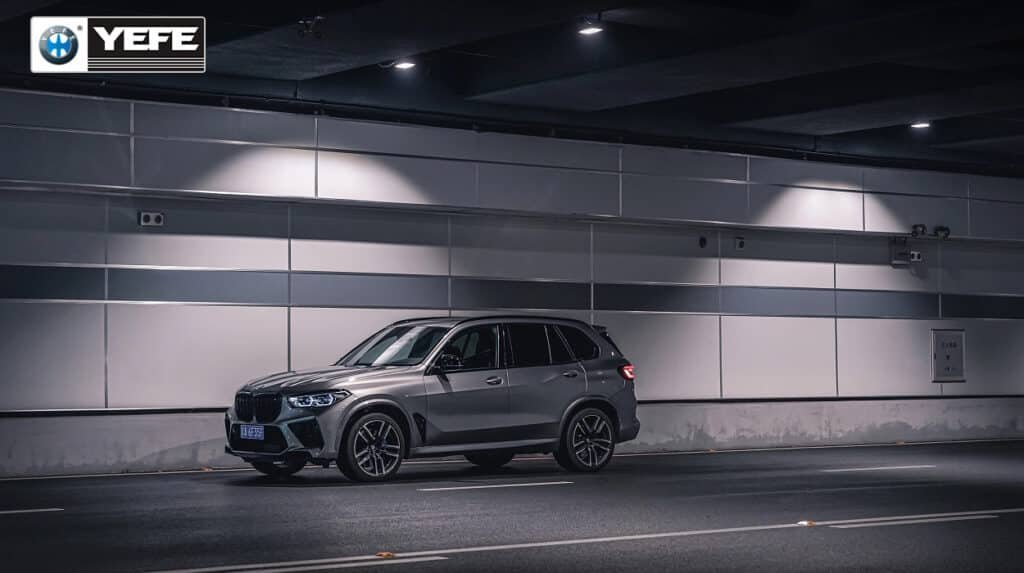 A sleek BMW X5M SUV parked in a modern underground tunnel, representing the demanding stop-and-go city driving environment. This image illustrates the need for high-performance engine oil like YEFE, designed to handle frequent idling, short trips, and thermal stress. Ideal for urban drivers seeking superior wear protection, sludge resistance, and consistent viscosity under real-world city conditions.