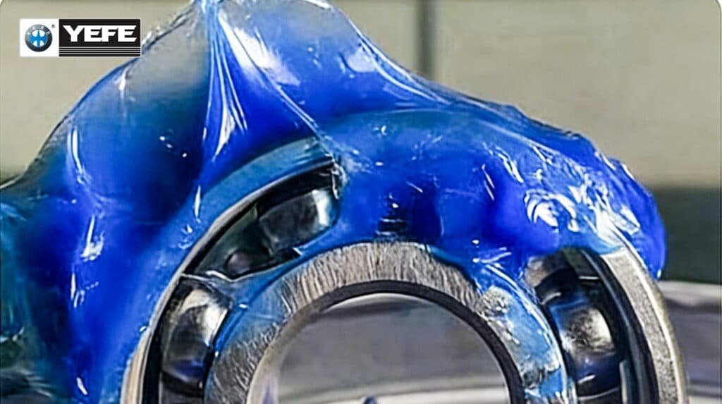 Close-up of automotive rolling bearing fully coated with YEFE low-noise synthetic blue polyurea grease, specially formulated for EV motor sealed-for-life bearings, features low starting torque, high thermal oxidation resistance and electrical insulation to prevent bearing pitting caused by stray current, optimizes vehicle driving range and reduces cabin NVH noise