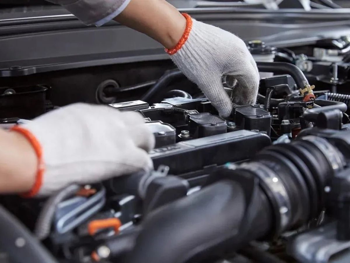 Technician performing maintenance on a commercial vehicle engine, representing fleet lubrication service and preventive maintenance