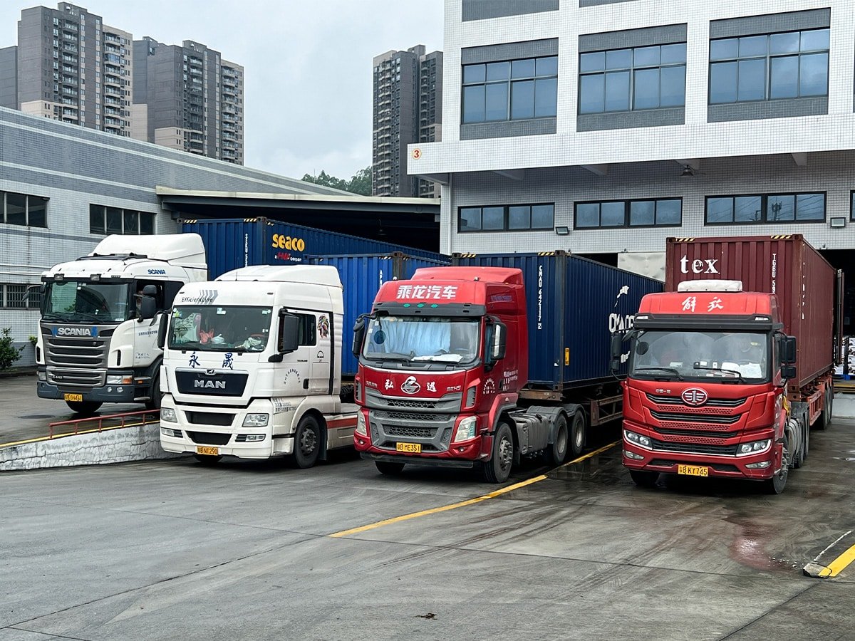 Fleet of container trucks at a logistics facility, representing heavy-duty lubricant solutions for commercial trucks and long-haul fleet operations