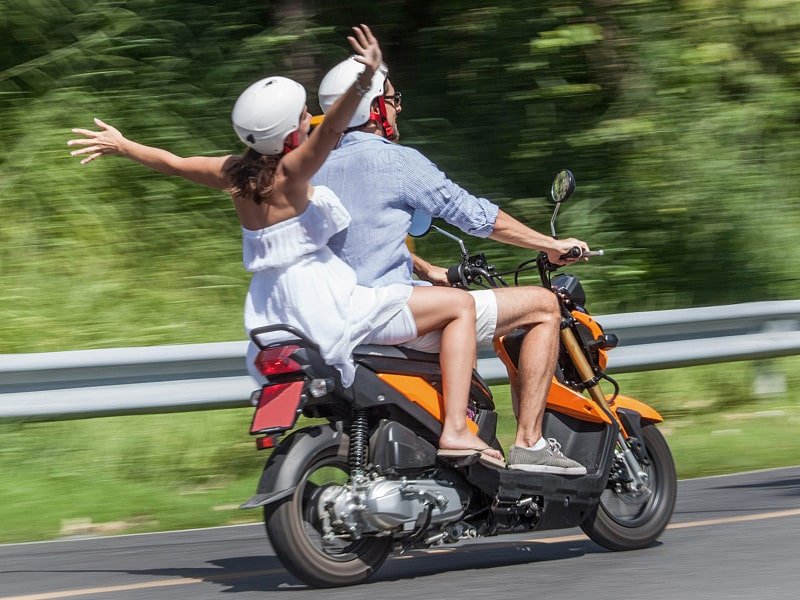 Two riders travelling on an urban scooter, representing reliable scooter engine oil for everyday commuting