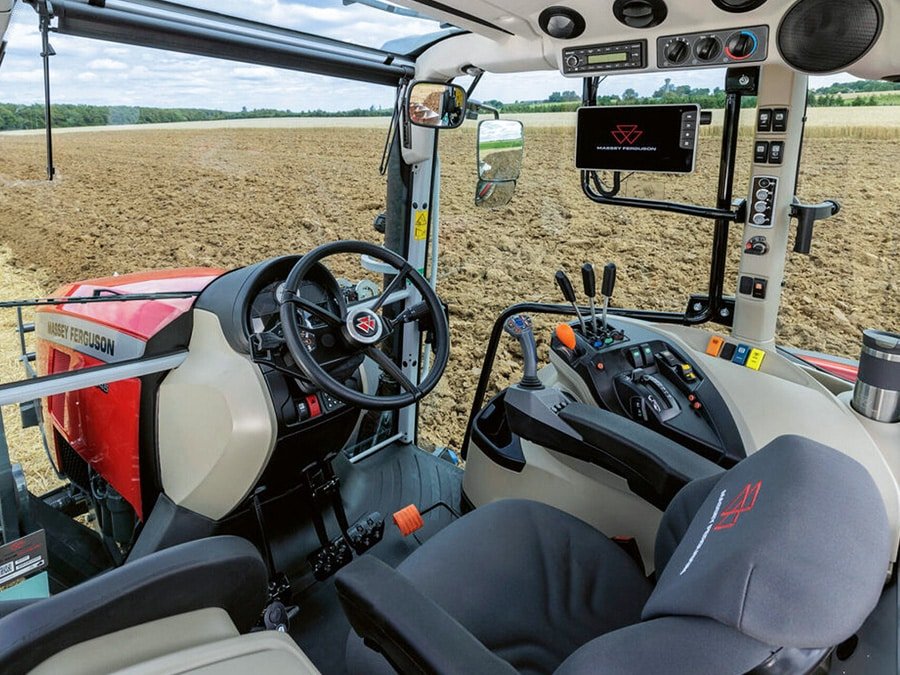Interior controls of a modern agricultural tractor in a cultivated field, representing hydraulic oil and tractor transmission fluid applications